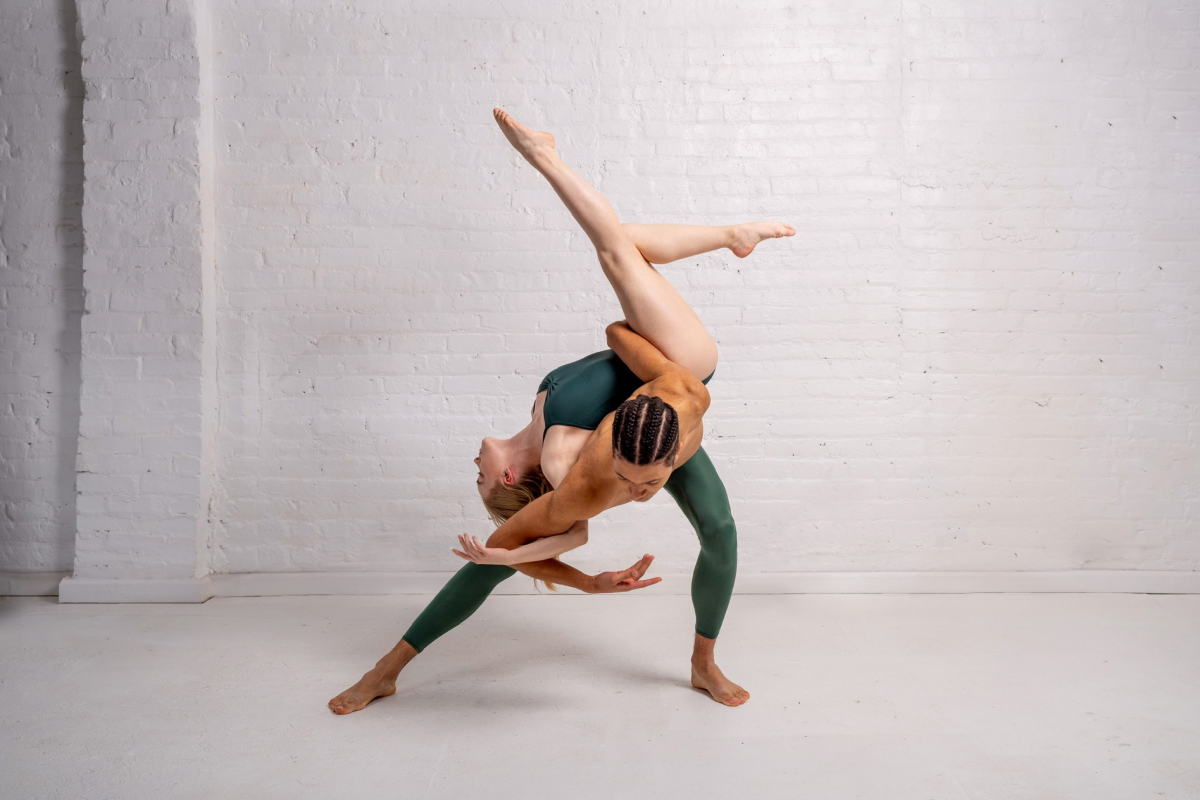 A male and female dancer expressively dancing in a white room